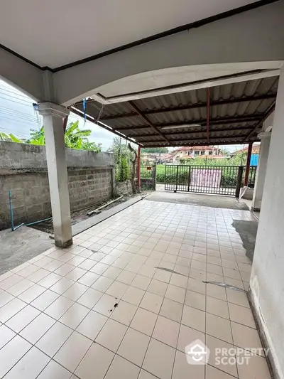 Spacious tiled carport with gated entrance in suburban home