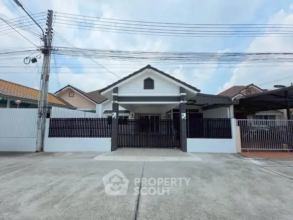 Charming single-story house with gated entrance and spacious driveway in a serene neighborhood.