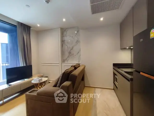 Modern living room with sleek kitchen, cozy sofa, and large window for natural light.