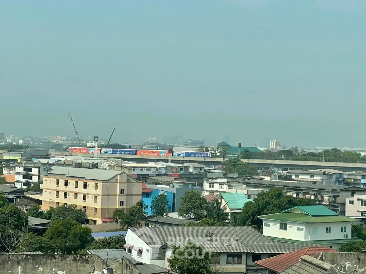 Panoramic cityscape view showcasing residential buildings and distant skyline.