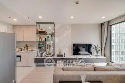 Modern living room with open kitchen, stylish decor, and large windows in a contemporary apartment.