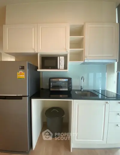 Modern kitchen with sleek appliances and white cabinetry, featuring a microwave and oven for convenient cooking.