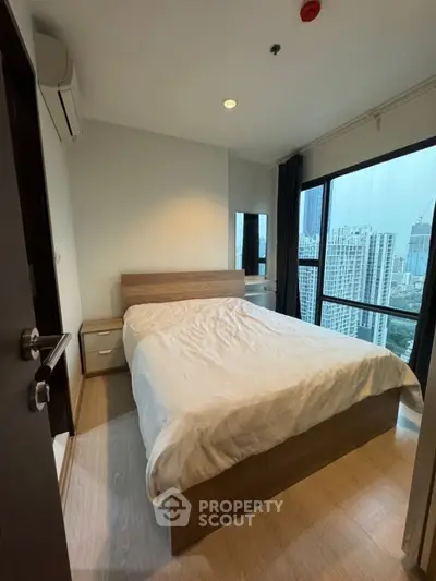 Modern bedroom with city view and natural light in high-rise apartment