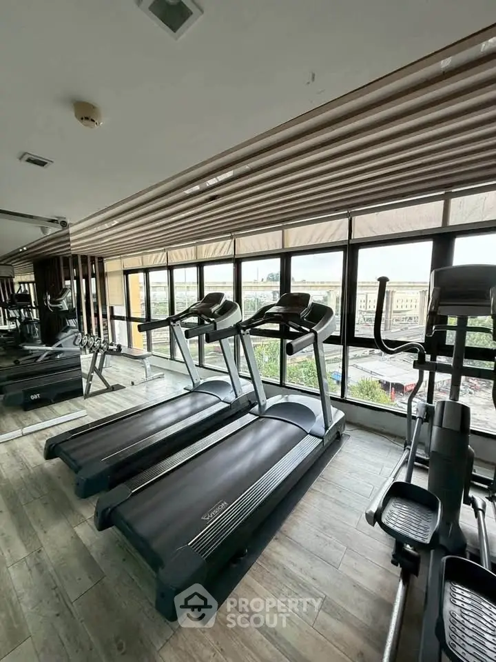 Modern gym with treadmills and large windows offering city views