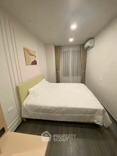 Modern bedroom with cozy bed and stylish decor in a well-lit apartment.