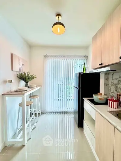 Modern kitchen with sleek design, featuring a breakfast bar and natural light.