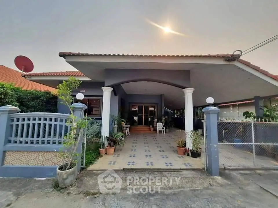 Charming single-story home with tiled entrance and lush greenery, perfect for serene living.