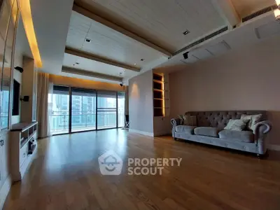 Spacious living room with modern design and large windows offering city views.