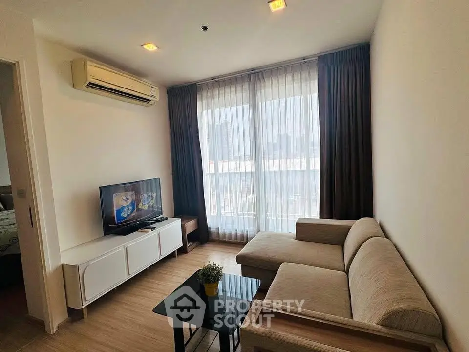 Modern living room with large windows and stylish furniture in a high-rise apartment.