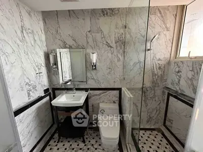 Luxurious marble bathroom with modern fixtures and glass shower enclosure