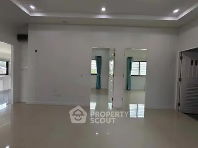 Spacious modern living area with tiled flooring and recessed lighting