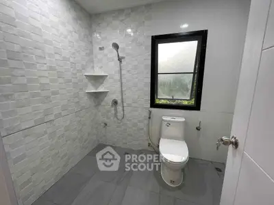 Modern bathroom with sleek tiles and natural light from window