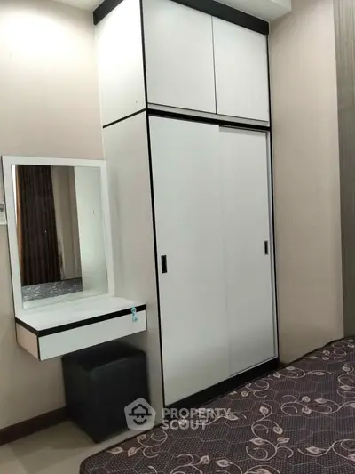 Modern bedroom with sleek wardrobe and stylish vanity in a cozy apartment.
