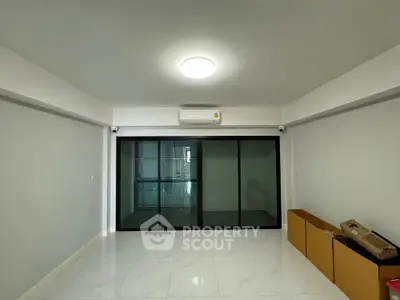 Spacious modern living room with sleek glass doors and air conditioning.