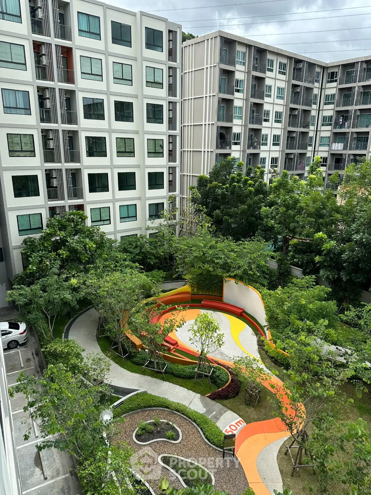 Modern apartment complex with lush garden and walking paths