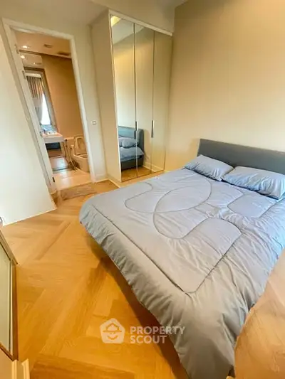 Cozy bedroom with modern decor and mirrored wardrobe, featuring an ensuite bathroom.