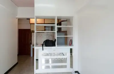 Spacious apartment interior with open shelving and tiled kitchen area, perfect for modern living.