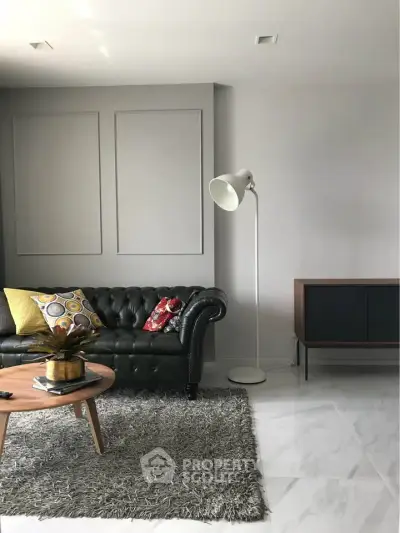 Stylish living room with leather sofa, modern lamp, and chic decor