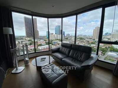 Stunning living room with panoramic city view, featuring modern leather sofa and sleek decor.