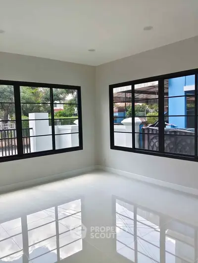 Bright corner unit with large windows and glossy tiled floors, offering a serene view of the outdoors.