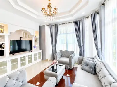 Luxurious living room with elegant chandelier and plush seating in a bright, airy space.