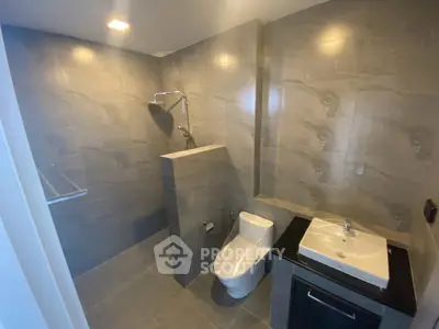 Modern bathroom with sleek design featuring a walk-in shower and contemporary fixtures.