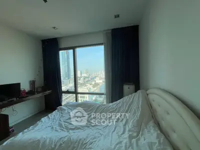 Modern bedroom with city view, featuring large window and stylish decor.
