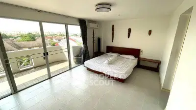 Spacious bedroom with balcony access and scenic view in modern apartment.