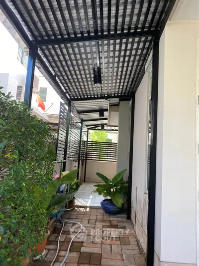 Charming covered patio with potted plants and tiled flooring, perfect for relaxation and outdoor enjoyment.