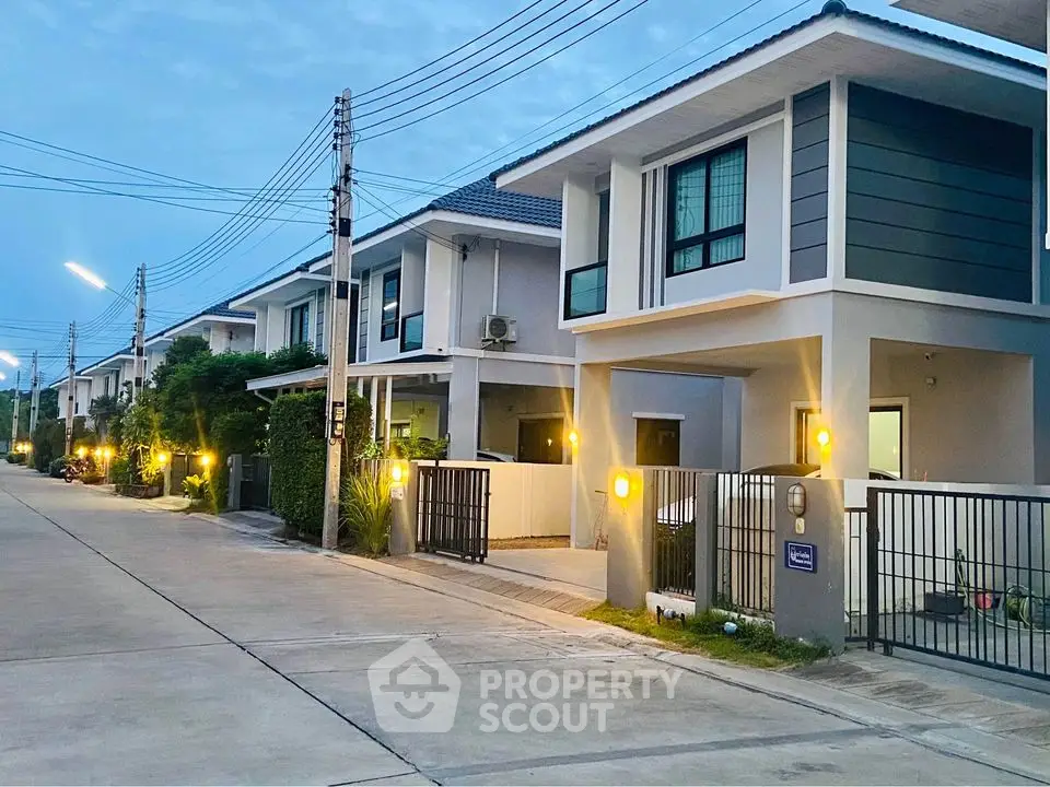 Modern suburban homes with sleek design and well-lit exteriors on a quiet street.