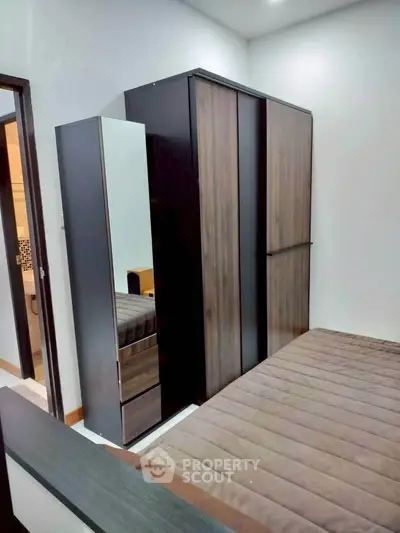 Modern bedroom with sleek wardrobe and cozy bed in stylish apartment.