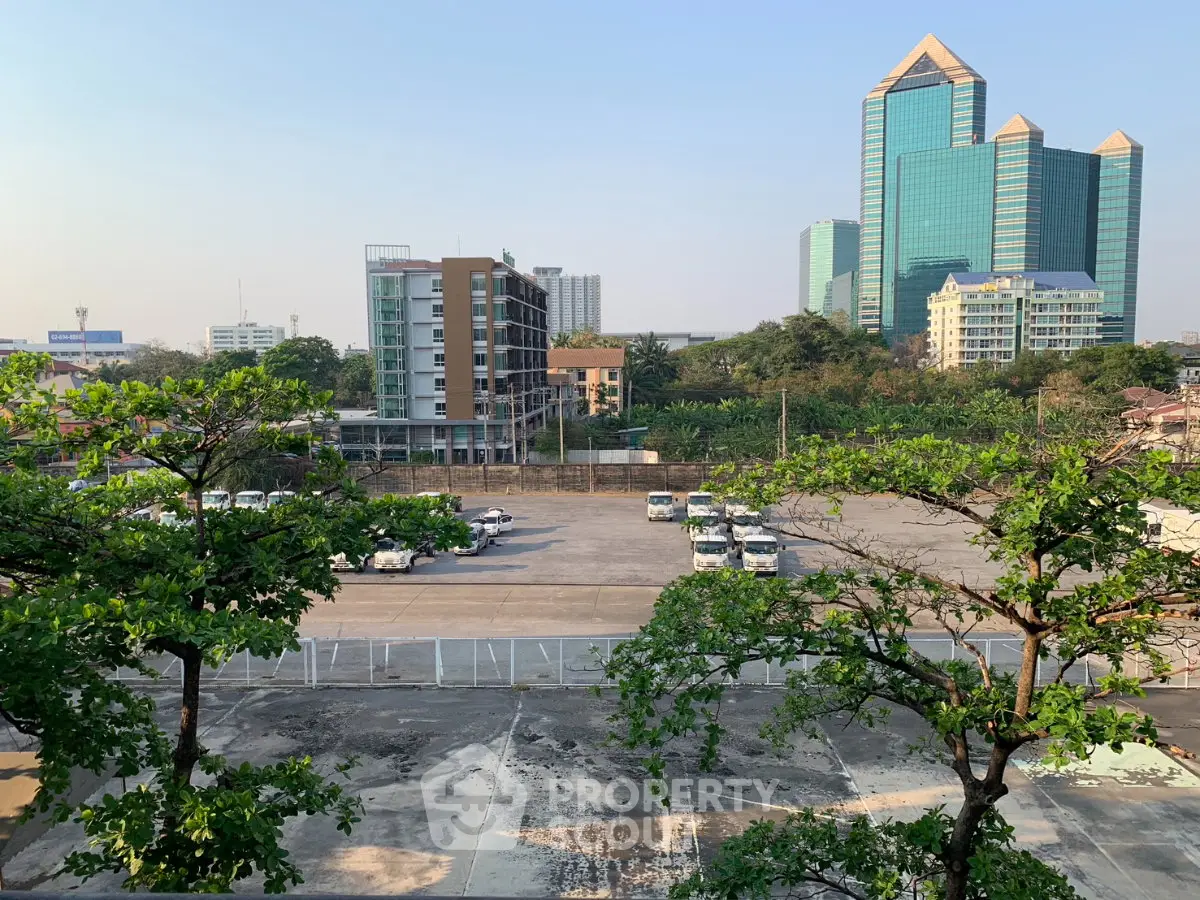 Stunning urban view with modern high-rise buildings and spacious parking area, perfect for city living.