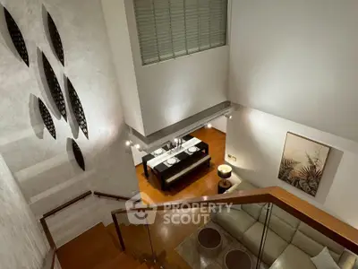 Elegant duplex living room with modern decor and dining area view