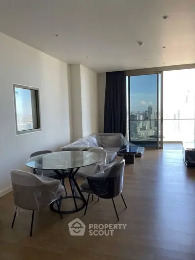 Modern living room with city view and stylish furniture in high-rise apartment.