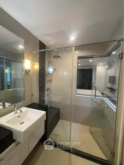 Modern bathroom with glass shower enclosure and sleek fixtures
