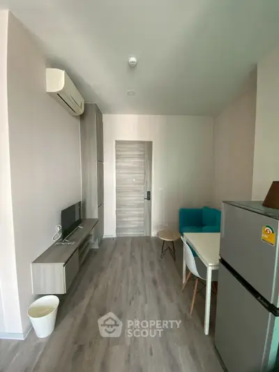 Modern compact living room with sleek furniture and integrated kitchen area, perfect for urban living.