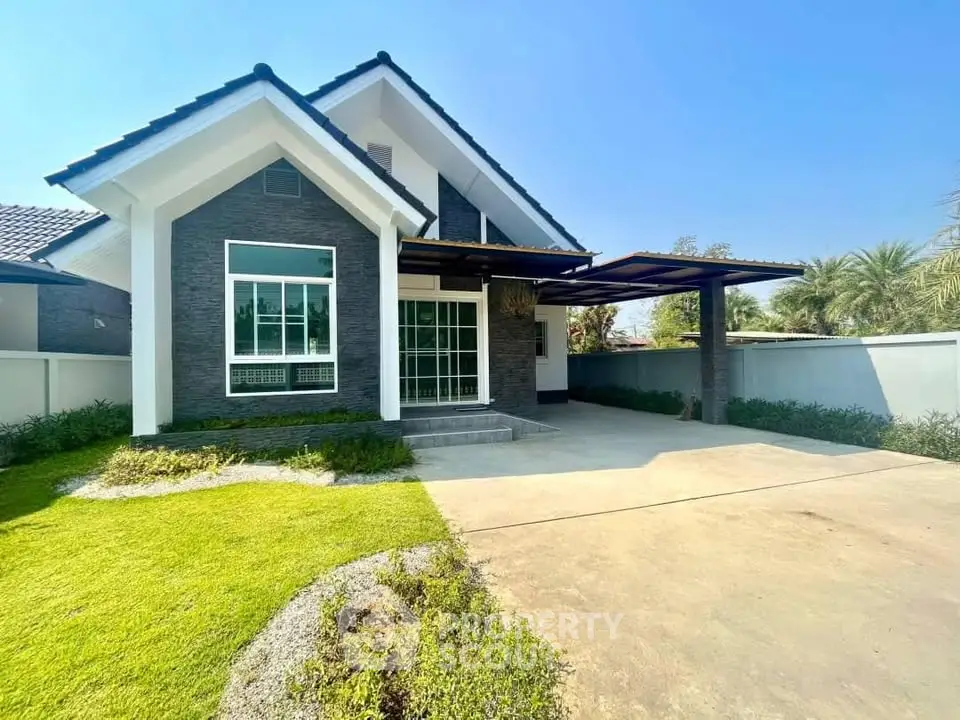 Charming modern house with spacious driveway and lush green lawn under clear blue sky.
