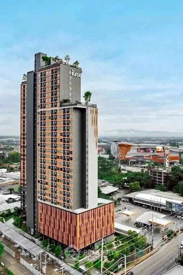 Stunning high-rise building with modern design and lush rooftop garden, offering panoramic city views.