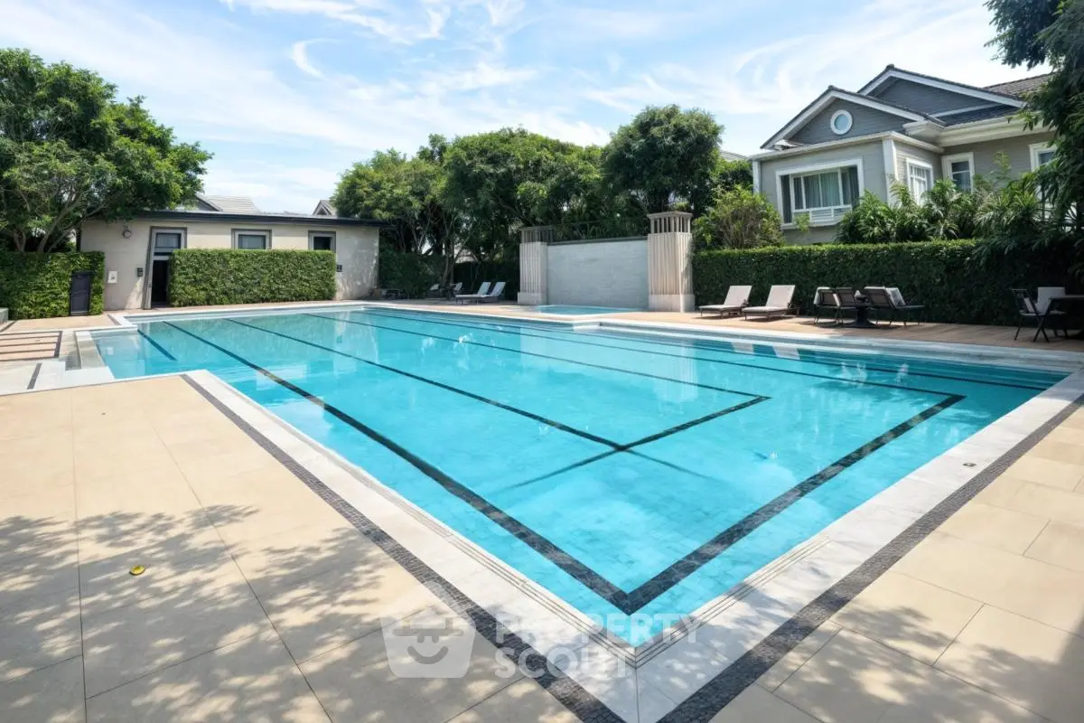 Luxurious residential pool area with modern design and lush greenery.