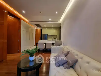 Modern living room with open kitchen, elegant sofa, and stylish decor