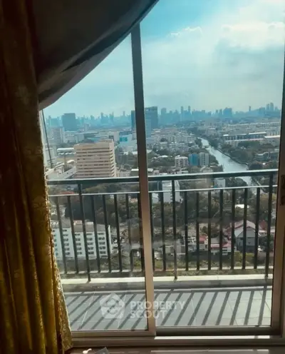 Stunning cityscape view from high-rise balcony with elegant curtains framing the scene.