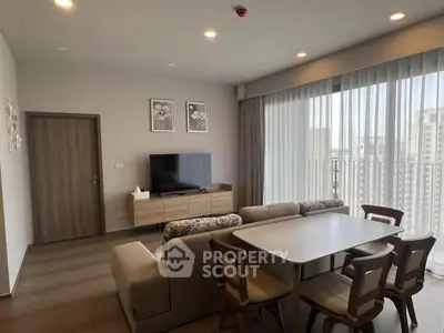 Modern living room with stylish furniture and large windows offering city views.