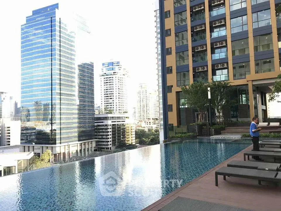 Luxurious rooftop pool with stunning city skyline views in modern high-rise building.