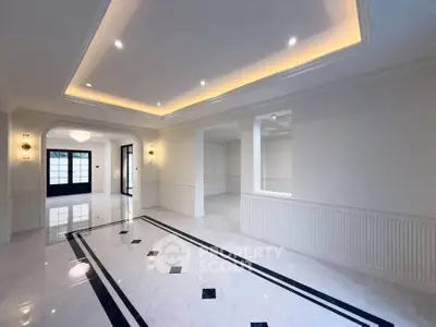 Spacious and elegant living room with modern lighting and marble flooring