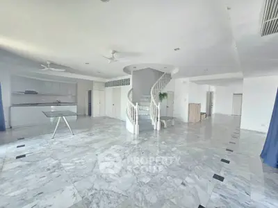 Spacious open-plan living area with marble floors and elegant spiral staircase