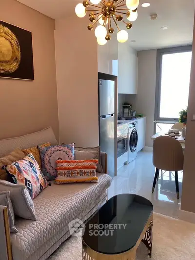 Chic modern living room with stylish decor and compact kitchen featuring stainless steel appliances.