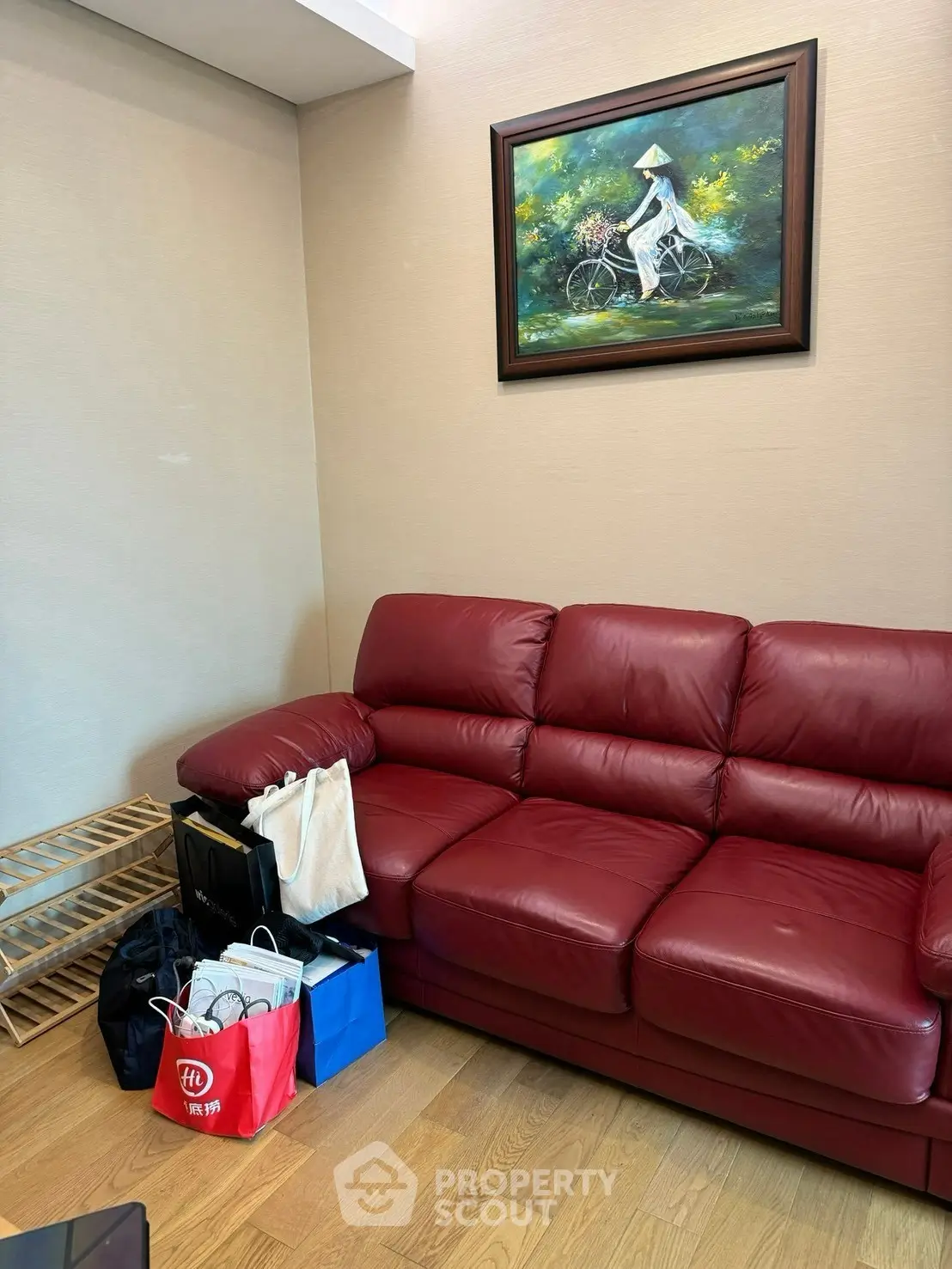 Cozy living room with red leather sofa and elegant wall art