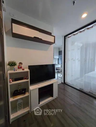 Modern living room with sleek TV setup and stylish decor in a contemporary apartment.