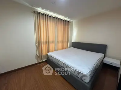 Spacious bedroom with large window and modern bed in a cozy apartment.