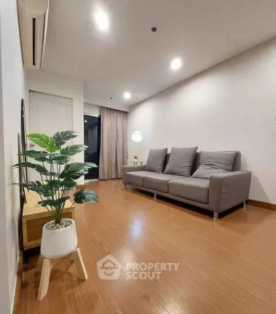 Modern living room with sleek gray sofa and wooden flooring, perfect for cozy relaxation.